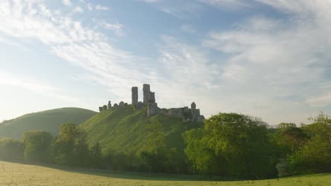 corfe castle bathed in a summer's morning sunrise, slow panning shot