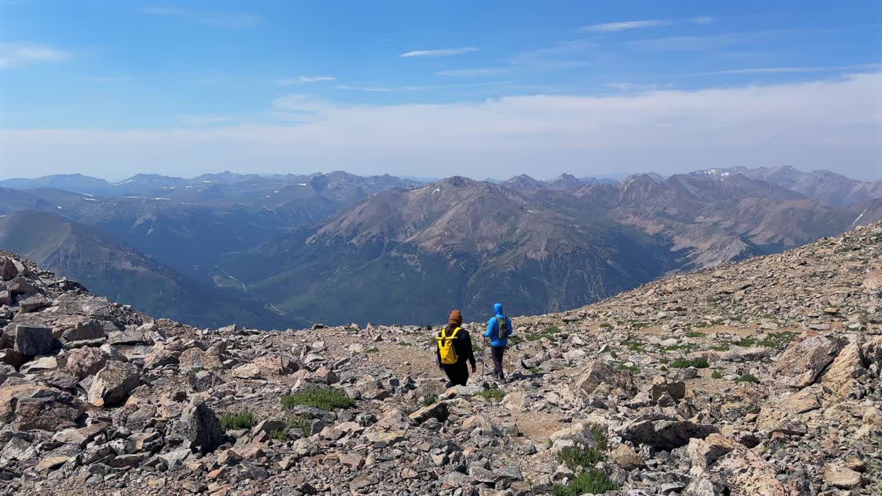 Summer hikers at La Plata Peak hiking trail Independence Pass Sawatch Range Rocky Mountains top of summit 14er Colorado aerial droneCollegiate Peaks switchback blue sky clouds haze static shot