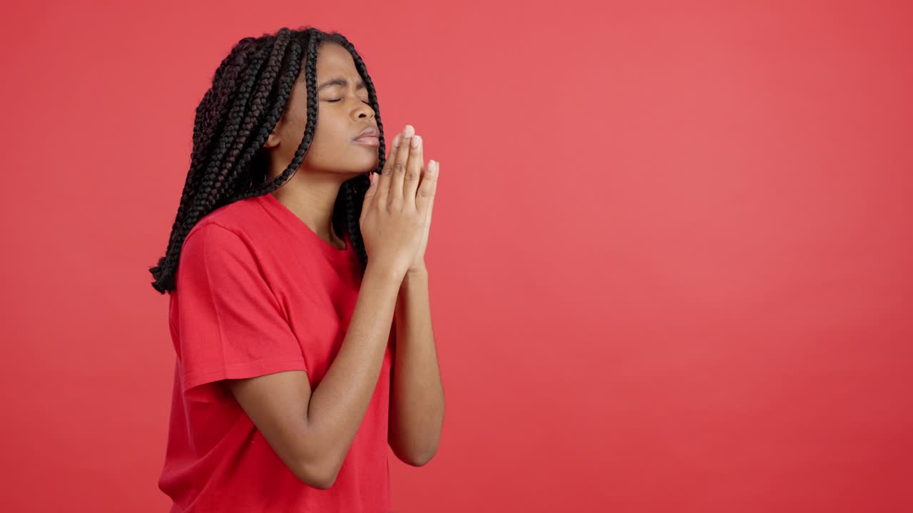 A woman in prayer on a red background