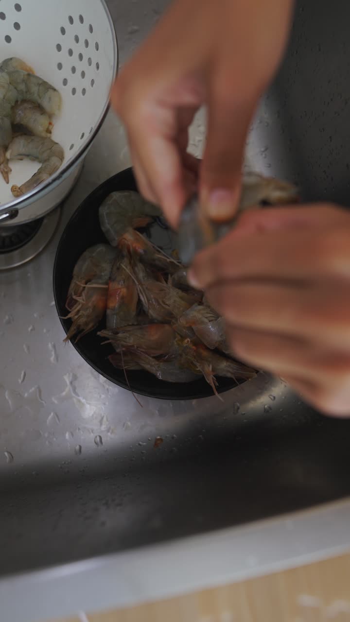 Cleaning raw shrimp in a kitchen sink