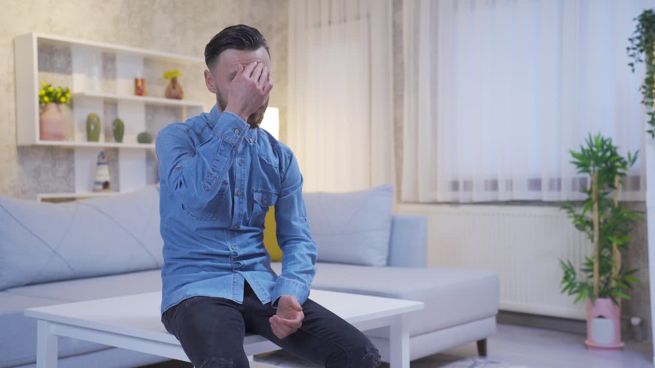 Depressed man alone at home bored, thinking and despairing.