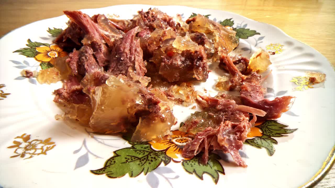 Close-up of cold meat jelly dish with shredded pork and gelatinous texture