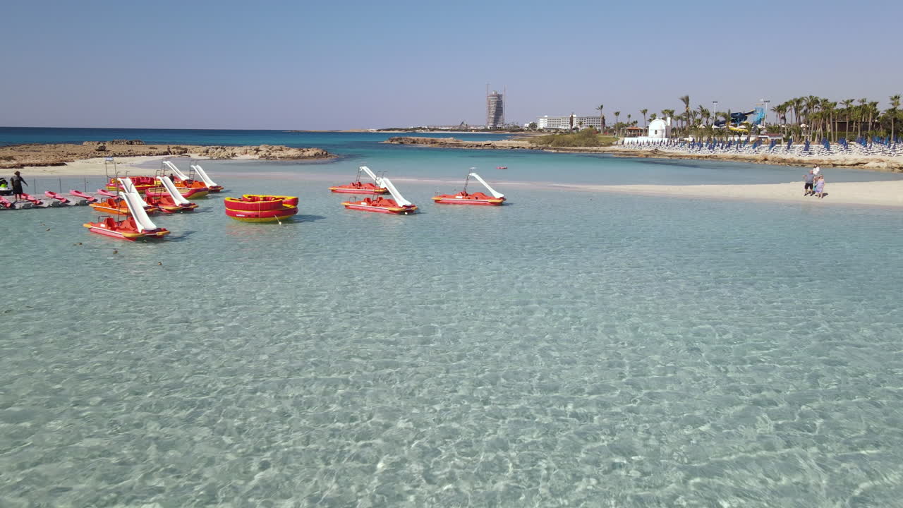 니시 해변, 아이아 나파 키프로스의 청록색 얕은 물에 정박한 페달 보트의 낮은 공중