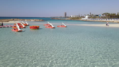 antena baja de botes a pedales amarrados en aguas turquesas poco profundas de la playa de nissi, ayia napa, chipre