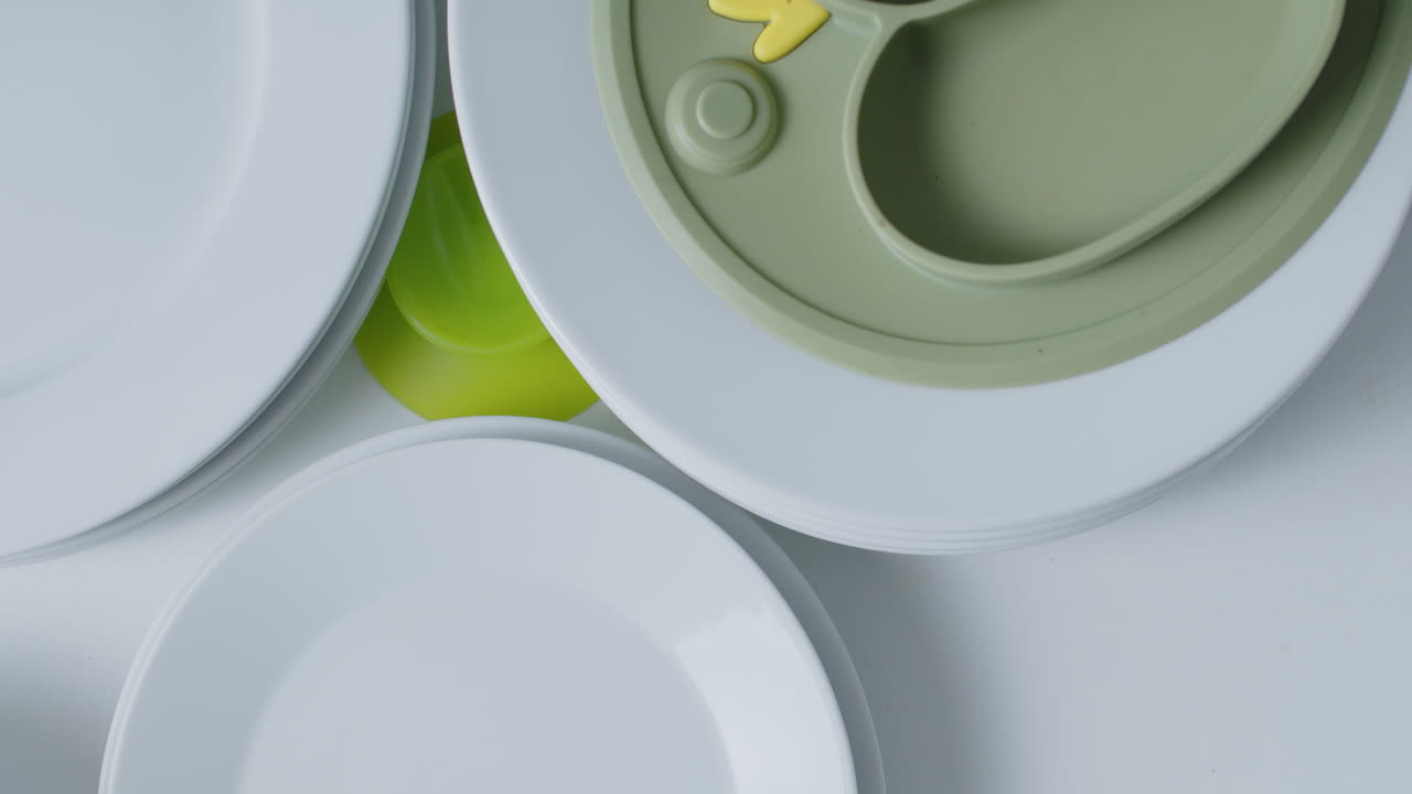 cerrando un cajón con platos de plata y abriendo el cajón de abajo con platos y cuencos