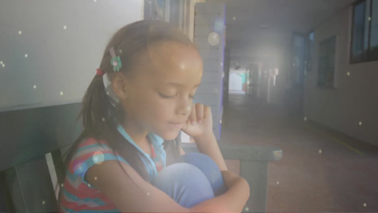 Icone digitali su ragazza seduta e pensierosa a scuola