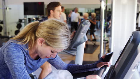 mujer haciendo ejercicio en una máquina de ciclismo en el gimnasio