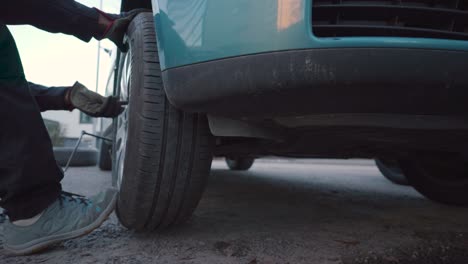 man mounting a tyre on a car