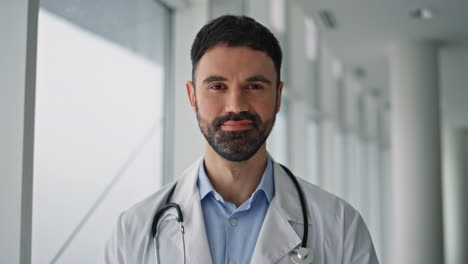 hospital professional looking camera indoors closeup. smiling man therapist