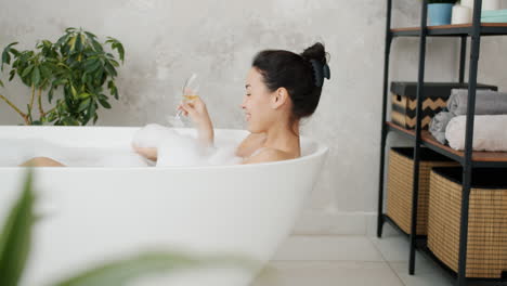 woman enjoying a bubble bath with champagne