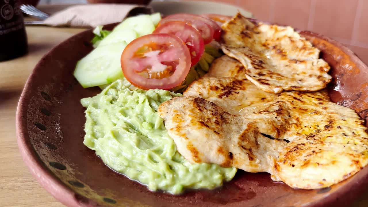 Grilled chicken with guacamole and sides, a typical Mexican dish