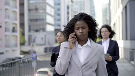 Businesswomen-with-digital-devices-on-street