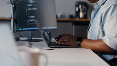 programmer working on a laptop and computer monitor