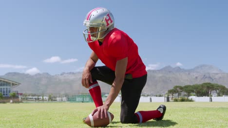 American-football-player-kneeling-with-ball