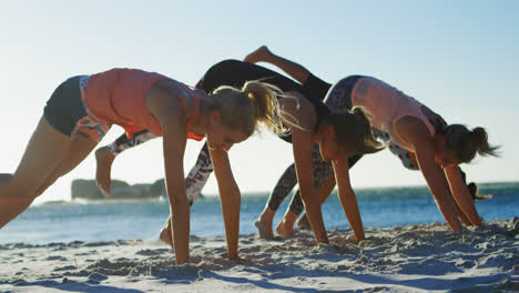 Female-volleyball-players-performing-yoga-in-the-beach-4k