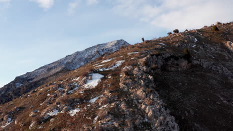 flying up and over the peak of a snow-dusted mountain near salt lake city, utah