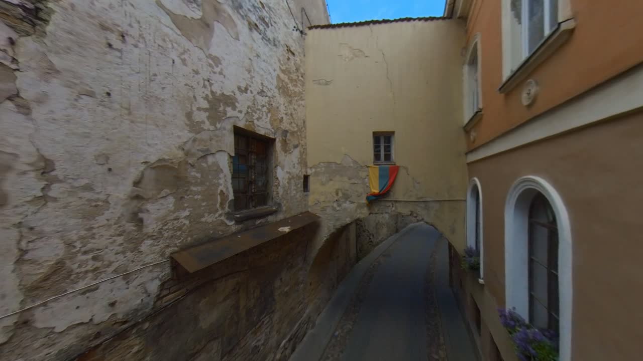 Bandiera lituana sopra l'arco nella stretta via del centro storico a Vilnius, Lituania.