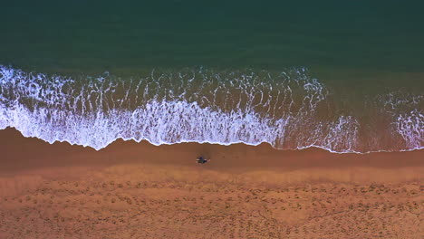 Woman-walking-through-waves-washing-on-tropical-sandy-beach,-Thailand