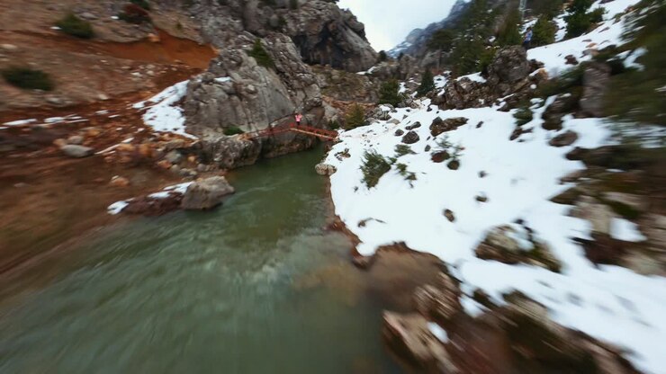 Donna che scatta una foto del fiume verde e blu.