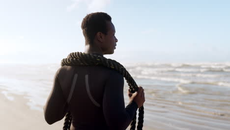 beach, black man and battle rope for fitness
