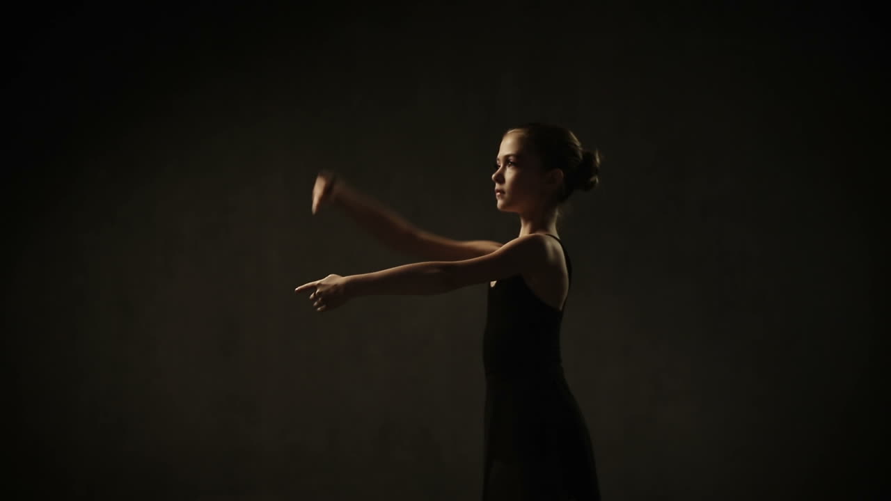 Young ballerina standing on poite in ballet studio