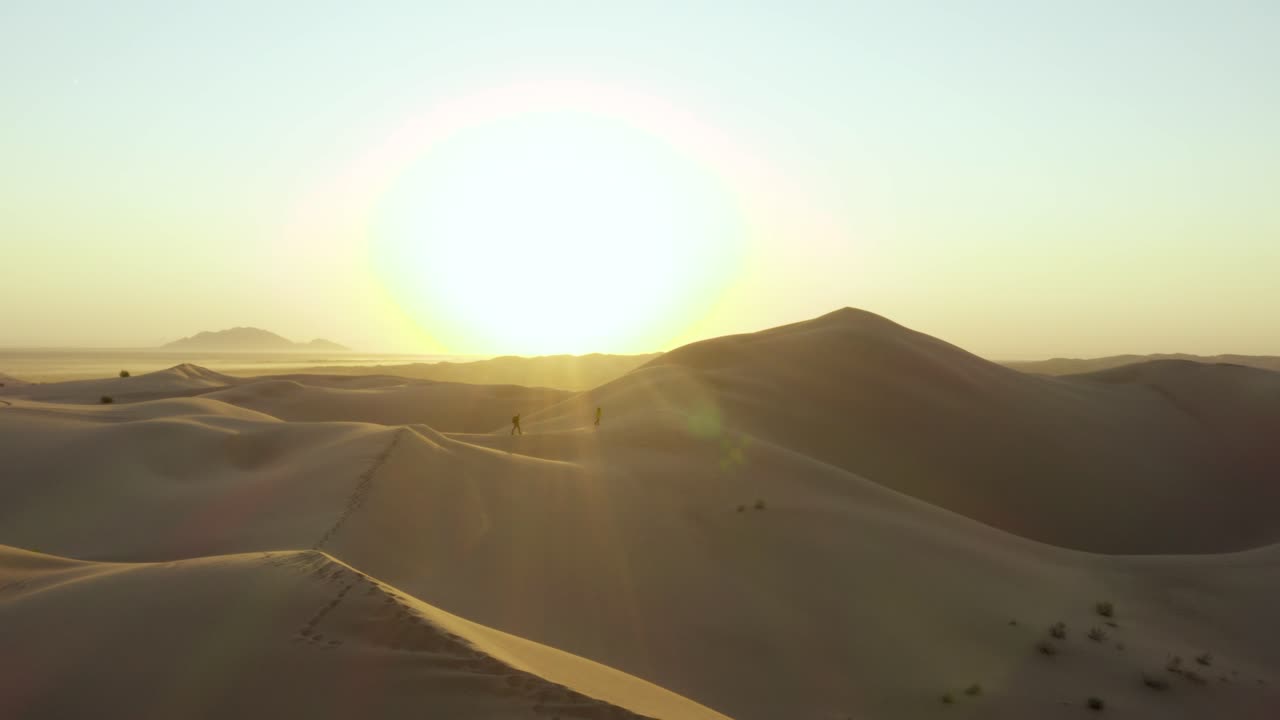 hermoso paisaje desolado de dunas de arena mientras los actores exploran un amanecer temprano