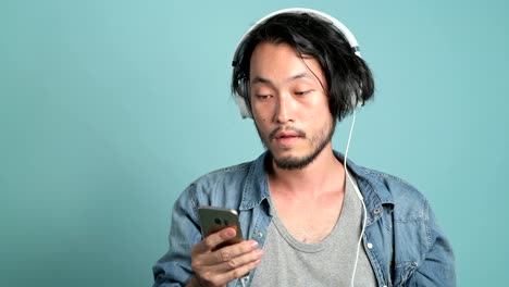 young bearded male hipster listening to music.