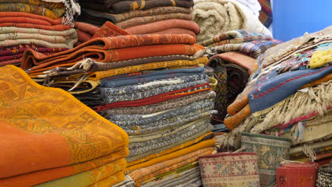 piles of persian carpets in a store