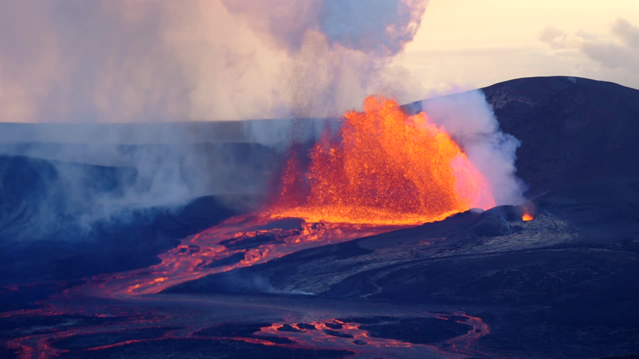 Veduta lontana di un potente vulcano che erutta al rallentatore con imponenti flussi di lava e fumo che si innalzano nel cielo.