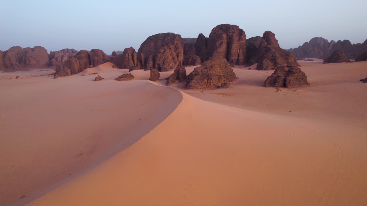 Sand Dunes At Sahara Desert With Sandstones In The Background At Sunrise In Tassili n'Ajjer National Park, Algeria