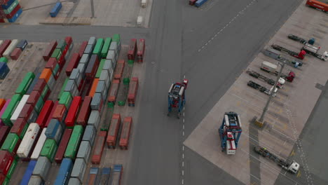 Aerial-overhead-view-following-a-forklift-operating-in-cargo-container-terminal-in-Hamburg,-Germany