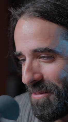 close-up of a bearded man talking into a microphone