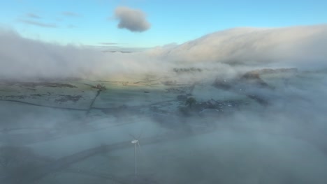 misty landscape with mountain covered in flowing cloud at dawn in winter