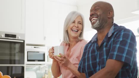 Feliz-Pareja-Diversa-De-Ancianos-Sentada-En-La-Sala-De-Estar-Y-Tomando-Café