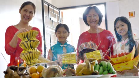 happy asian family praying for a prosperous in chinese new year celebrations