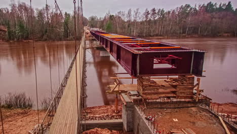 largo lapso de tiempo de un puente de acero que se está construyendo sobre el río gauja en letonia