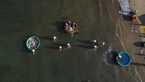 aerial top view of people in the sea loading trucks and cleaning boat