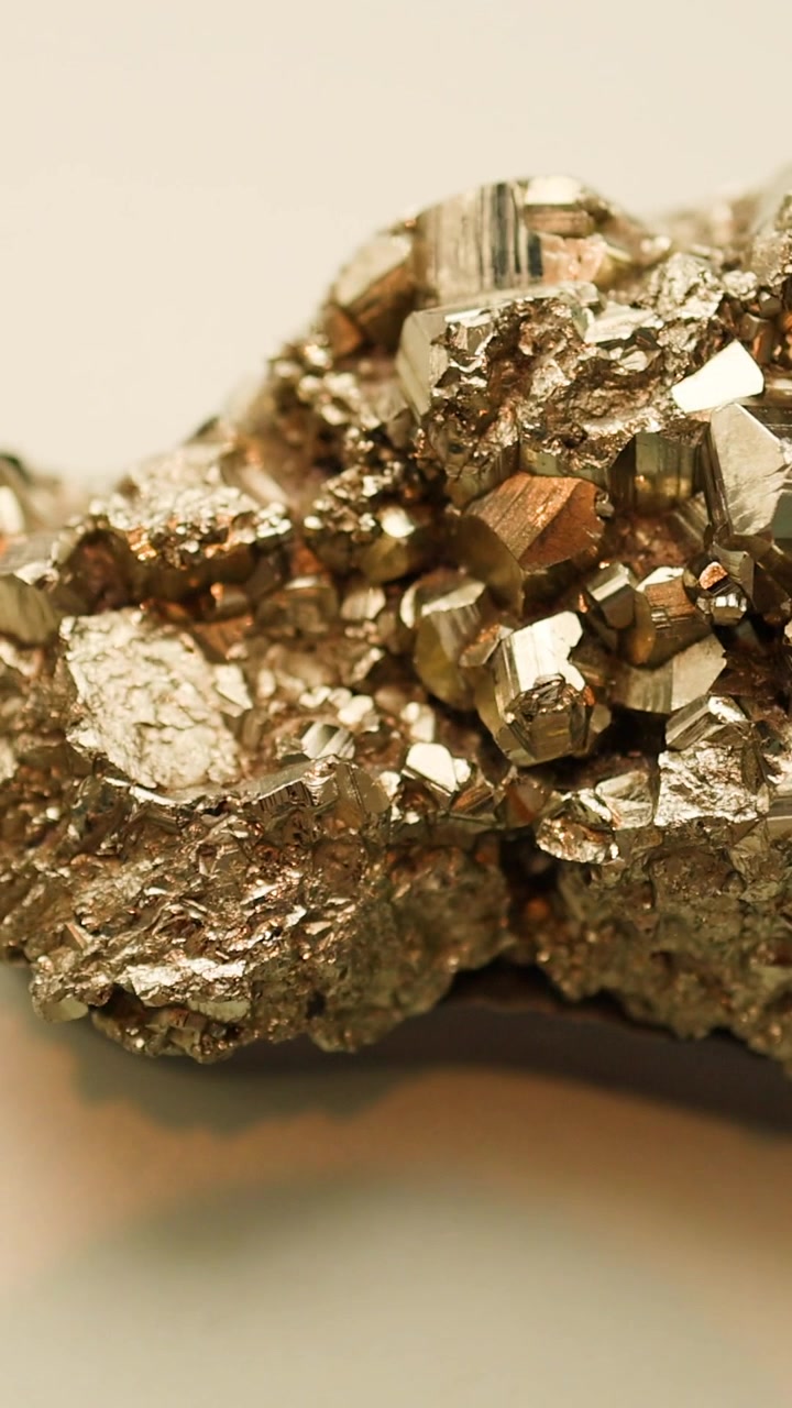 Primo piano estremo che mostra l'intricata struttura cristallina e il luccichio metallico di un campione di minerale d'oro.