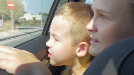 mother and son looking out car window