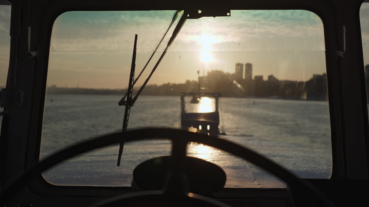 View from a boat's cabin at sunrise or sunset with a city skyline