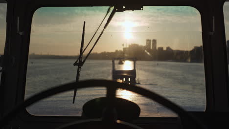 view from a boat's cabin at sunrise or sunset with a city skyline
