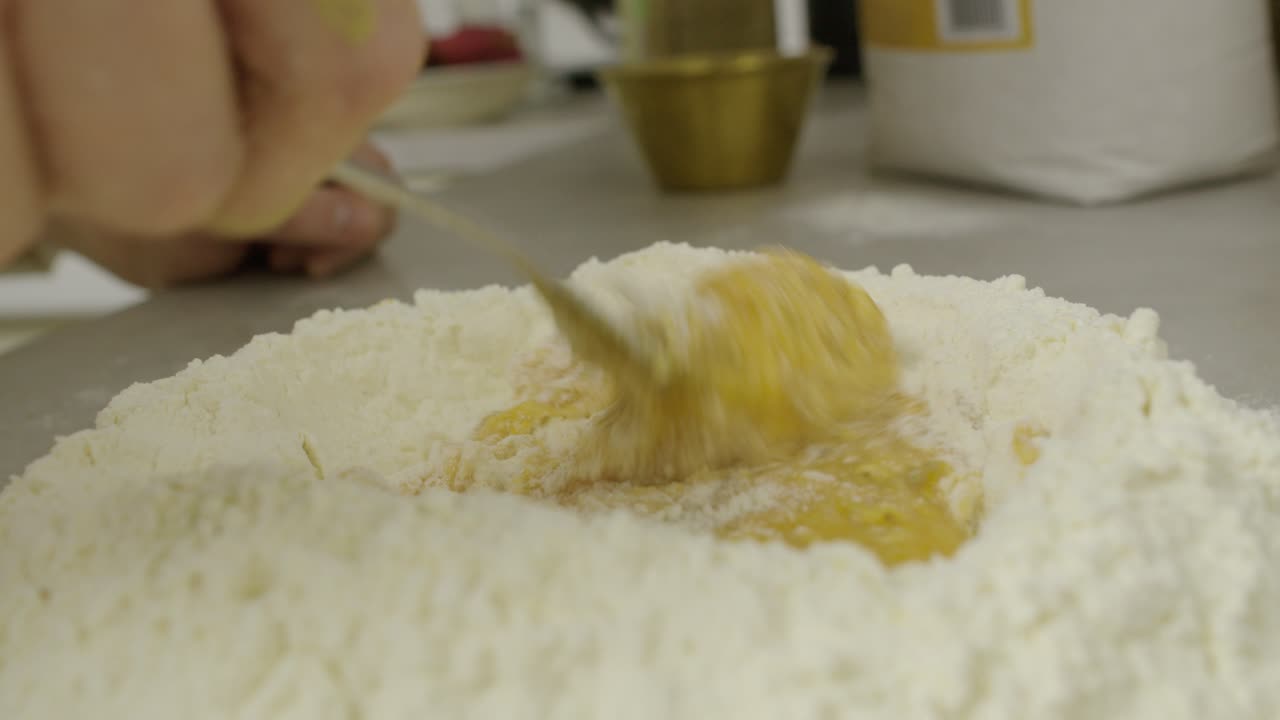 부엌 요리 테이블에 포크를 사용하여 계란 노른자와 밀가루를 혼합