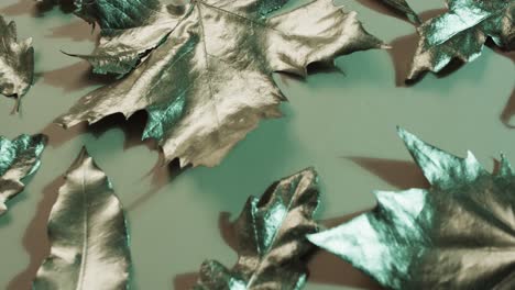 video of halloween autumn metallic leaves with copy space on green background