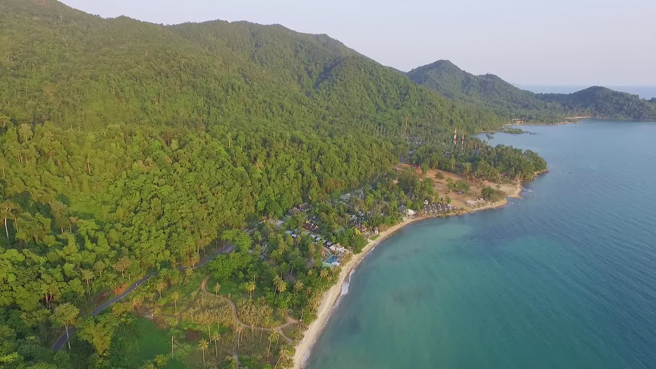 rotación de giro de drones de isla tropical con exuberante selva tropical y palmeras tropicales con playa de arena blanca y costa rocosa
