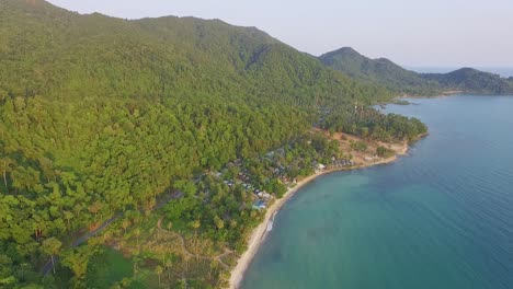 Rotación-De-Giro-De-Drones-De-Isla-Tropical-Con-Exuberante-Selva-Tropical-Y-Palmeras-Tropicales-Con-Playa-De-Arena-Blanca-Y-Costa-Rocosa