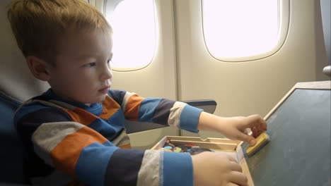 little boy in the plane with wooden box