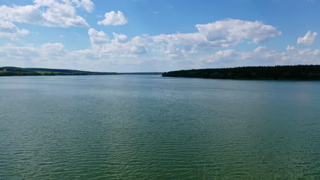 evening water under blue sky. beautiful wide river landscape. calm river among fields and forests. aerial flight.