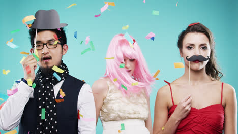 Three-attractive-friends-dancing-at-party-confetti-shower-slow-motion-photo-booth