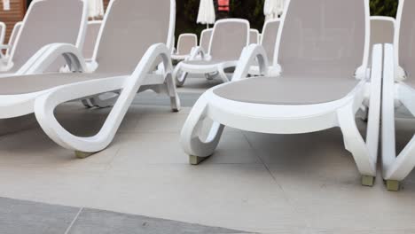 empty lounge chairs by the pool