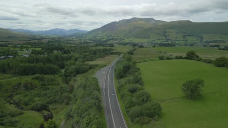Passing-high-over-rural-highway-A66-on-cloudy-summer-day-with-mountain-Blencathra-on-horizon